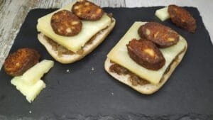TAPA PINCHO TOSTÁ CANAPÉ DE MORCILLA CON QUESO Y CEBOLLA caramelizada de Guadalmez