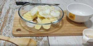 Lubina pescado en el horno con patatas, cebolla, pasas y jamón.